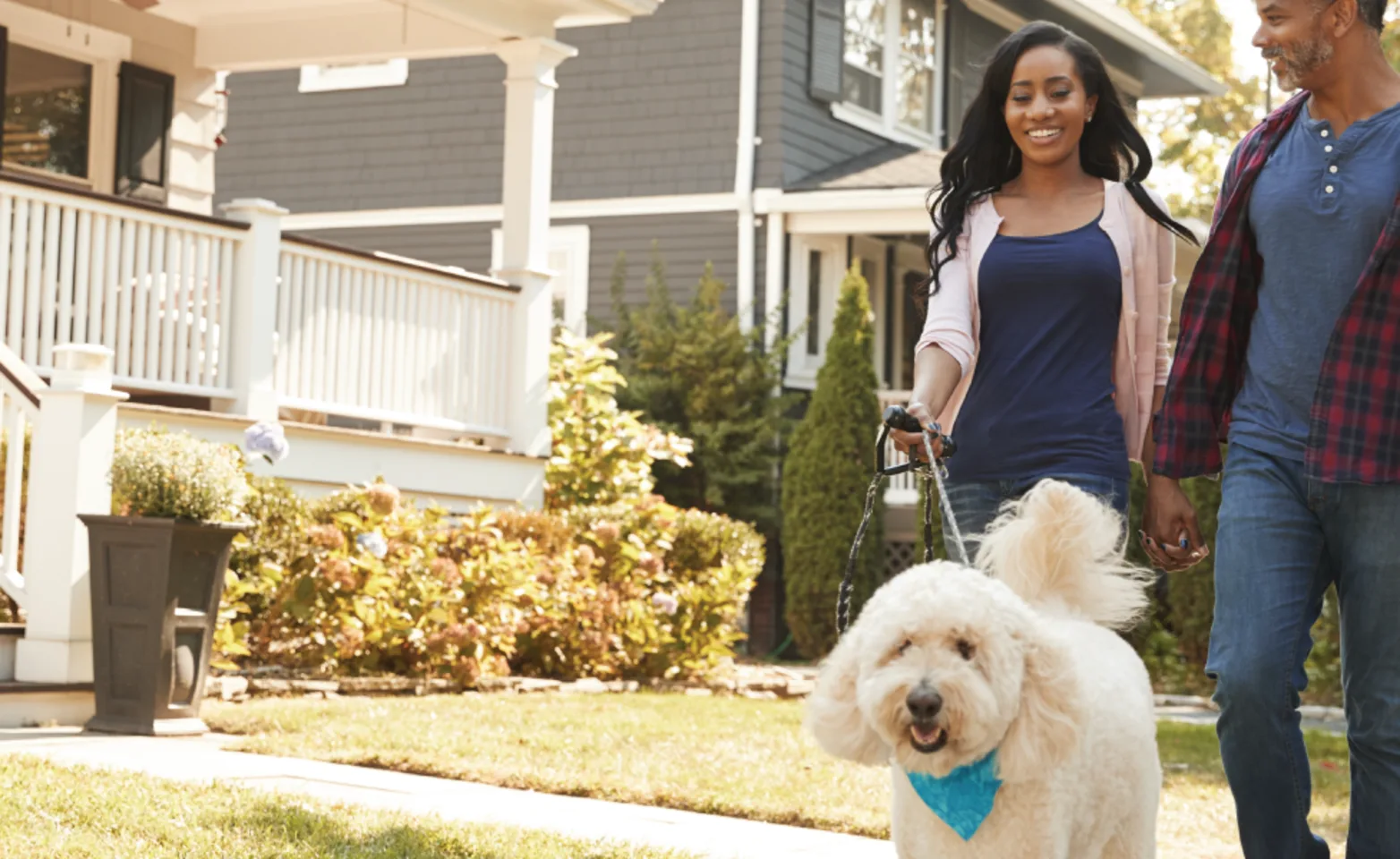 Family walking dog out in front of house